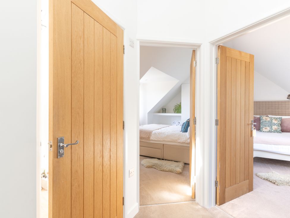 A view of open doors leading into a bedroom at Tokenhill Cottage in Piddletrenthide