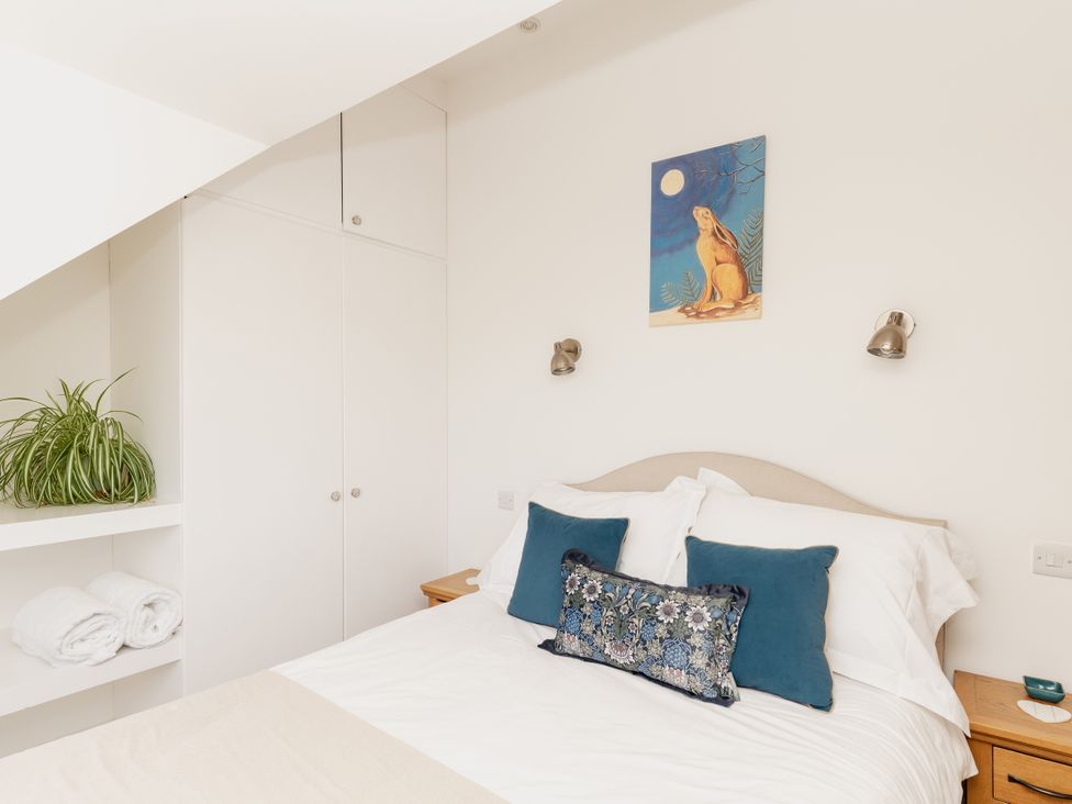 A bedroom with a bed and a plant at Tokenhill Cottage in Piddletrenthide