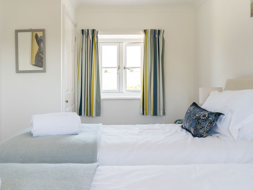 A bedroom with twin beds and a window at Tokenhill Cottage in Piddletrenthide