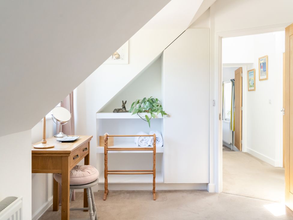 A hallway with a desk and mirror at Tokenhill Cottage in Piddletrenthide