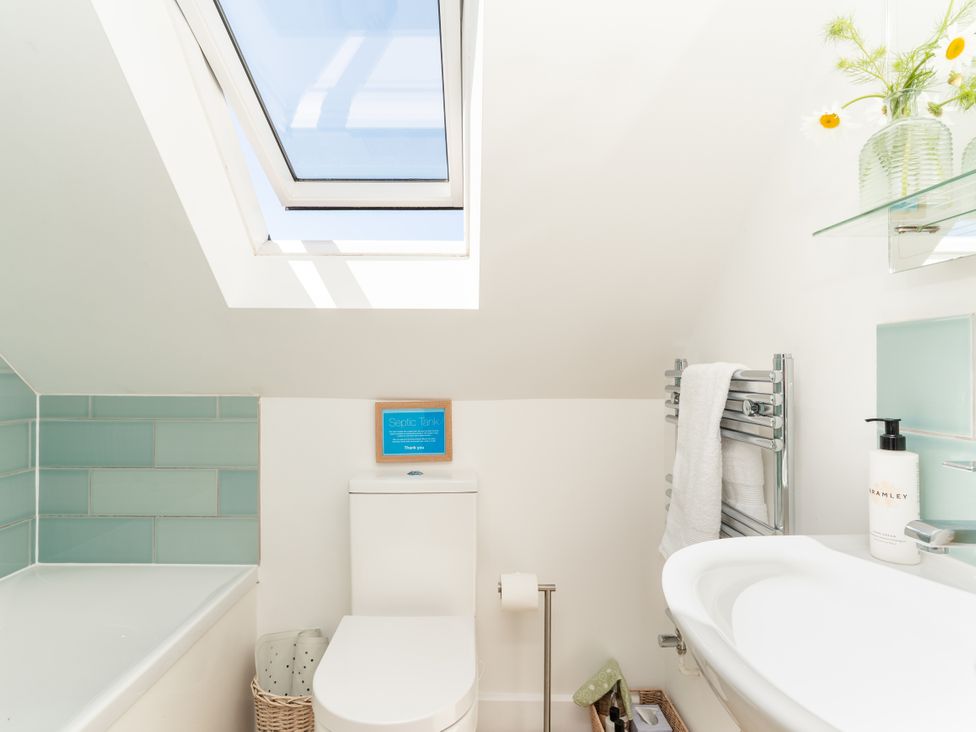 A bathroom with a toilet and bath tub at Tokenhill Cottage in Piddletrenthide