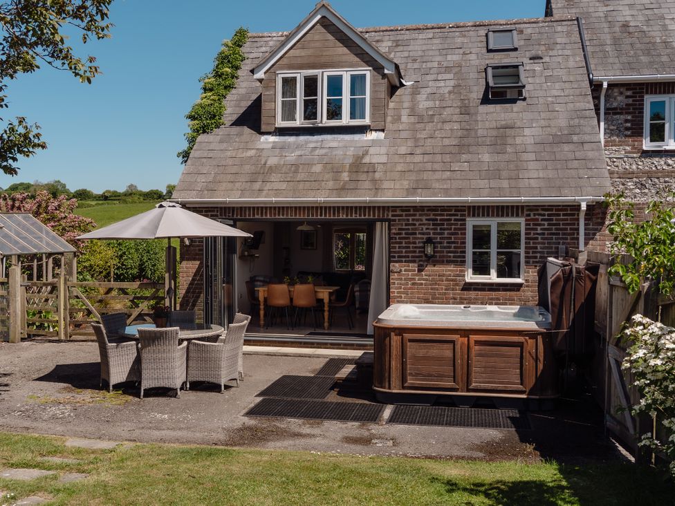 An outdoor area with a hot tub and seating at Tokenhill Cottage in Piddletrenthide