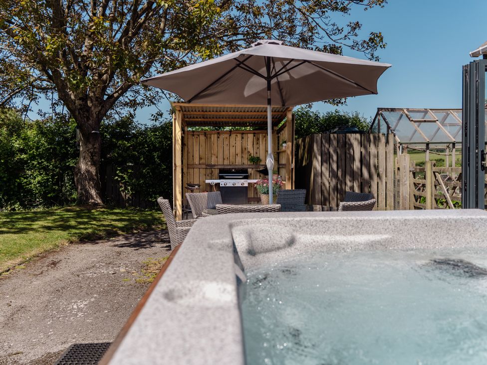 A garden with a hot tub and outdoor kitchen at Tokenhill Cottage in Piddletrenthide