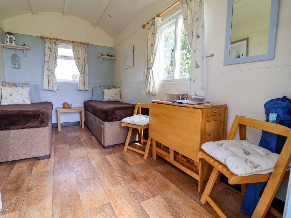 A sleeping area with two beds and a wooden table at Quackin' Up