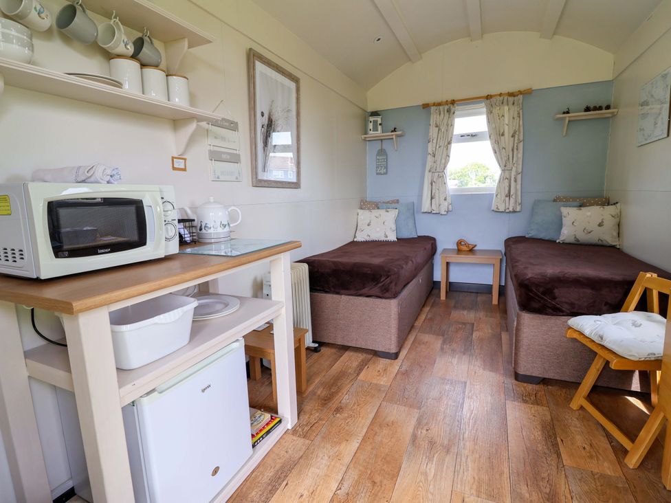 A bedroom with two beds and a kitchenette area at Quackin' Up