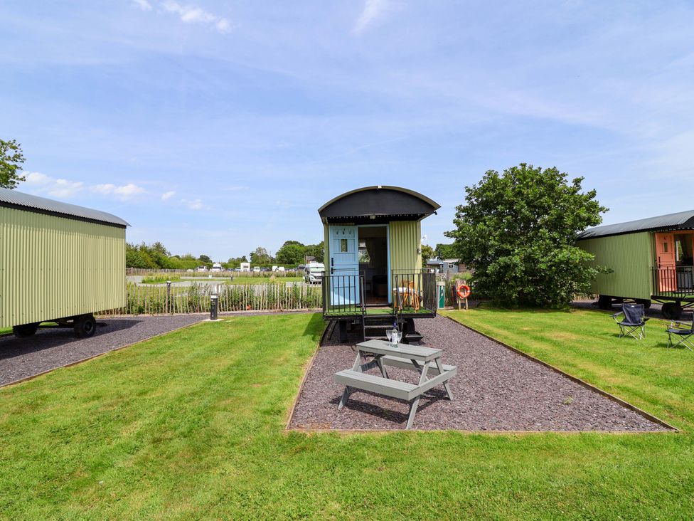 An outdoor area with huts and a picnic table at Quackin' Up