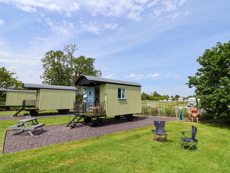 An outdoor area with shepherd's huts and seating at Quackin' Up 
