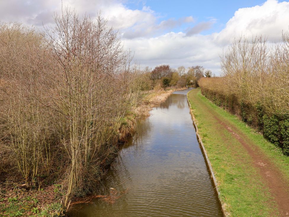 A canal with trees and a path at Quackin' Up