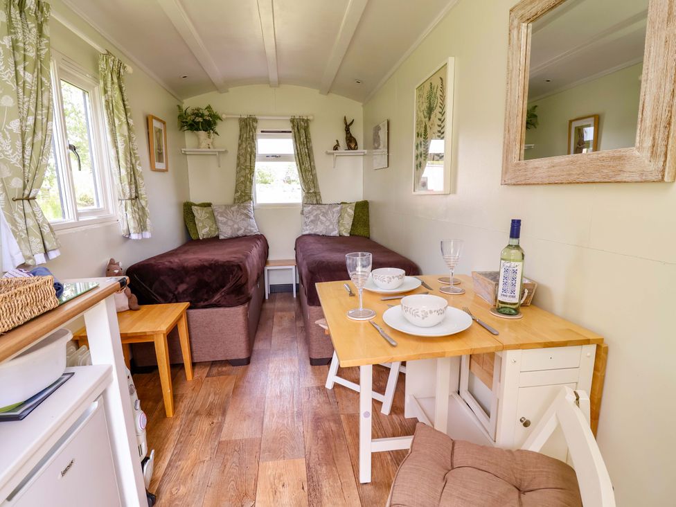 A living room with two beds and a dining table at Hop To It