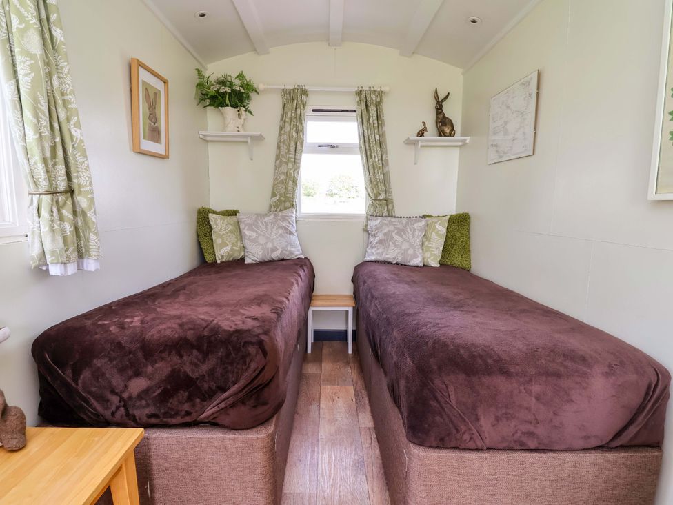 A bedroom with two beds and decorative items at Hop To It