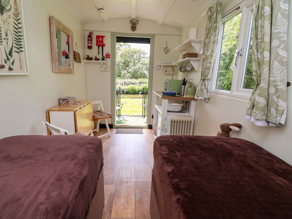 A bedroom with twin beds and a kitchenette at Hop To It