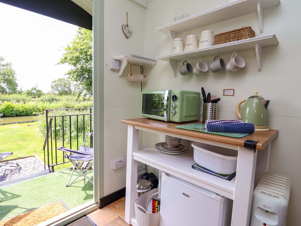 A kitchenette with a microwave and kettle at Hop To It 