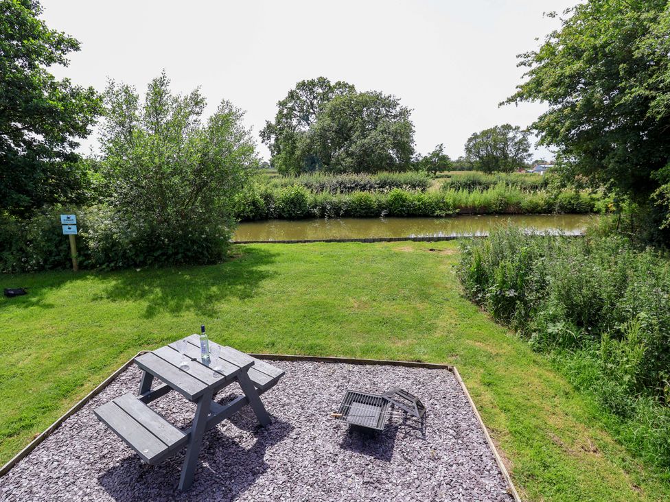 A table with a bottle near a river and grass at Hop To It