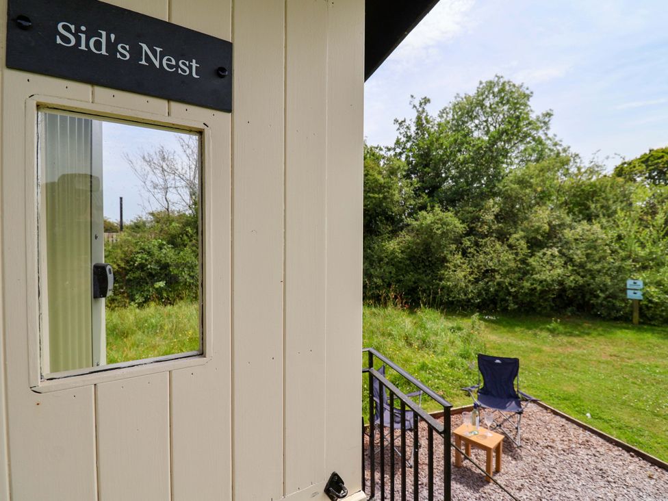An outdoor view from Sid's Nest with chairs and a table in the garden