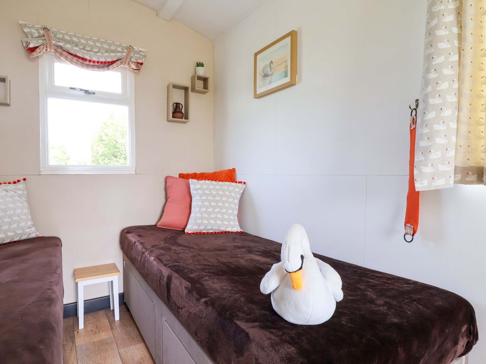 A bedroom with beds and cushions at Sid's Nest