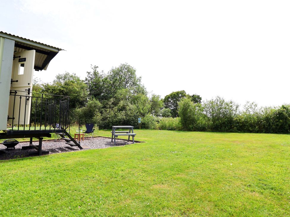 An outdoor area with a hut and seating at Sid's Nest