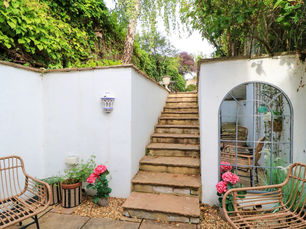 A garden with stairs and outdoor seating at Lower Pack Horse Cottage in Winchcombe