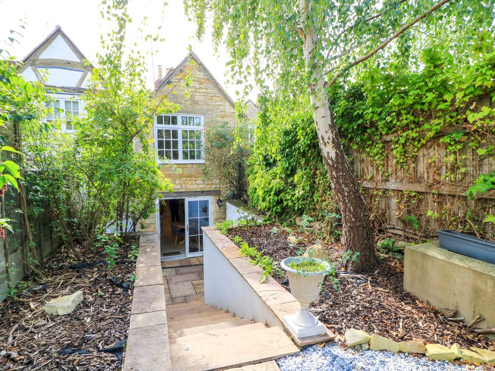 A garden with steps leading to an entrance at Lower Pack Horse Cottage in Winchcombe