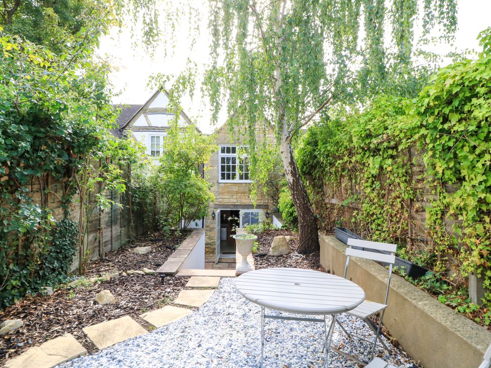 A garden with a table and chairs at Lower Pack Horse Cottage in Winchcombe