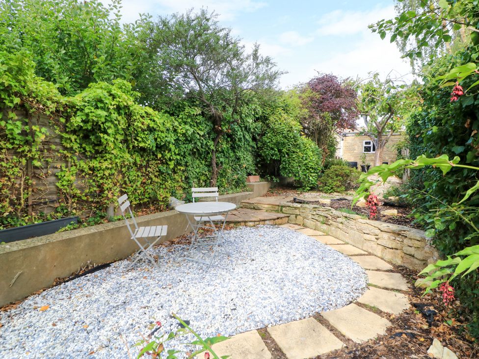 A garden with a table and chairs at Lower Pack Horse Cottage in Winchcombe