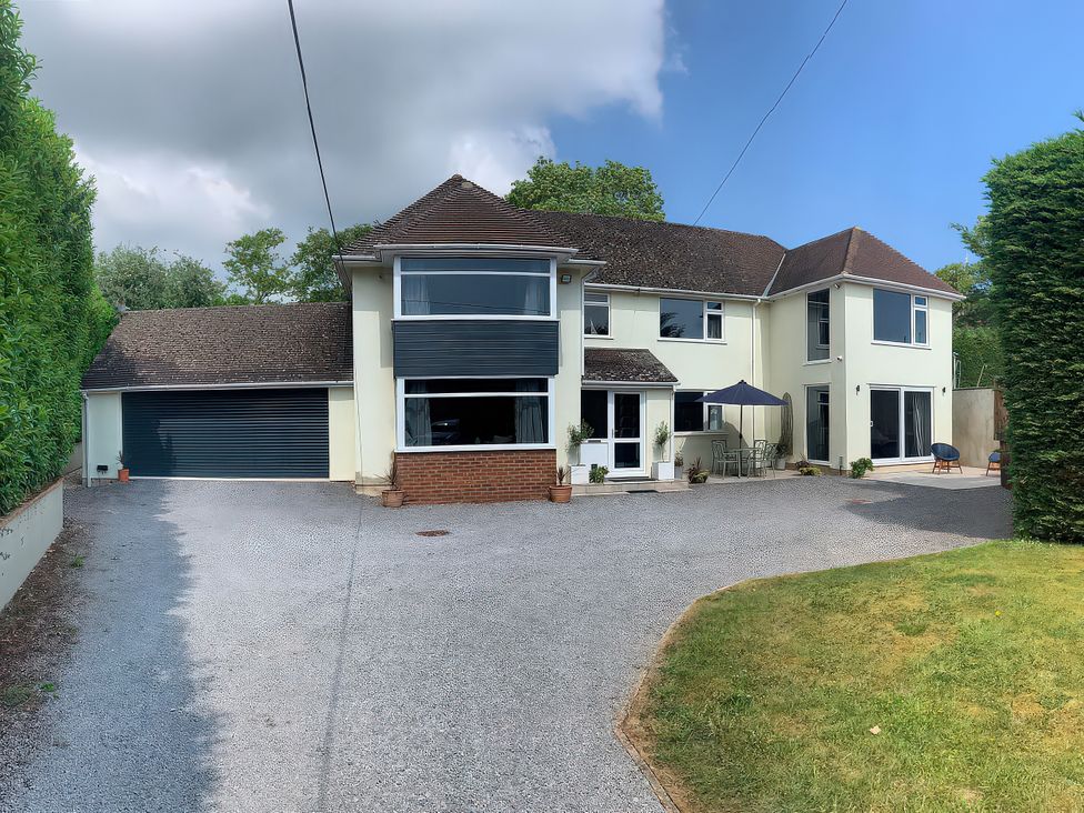 A house with a driveway and outdoor seating at Brooklands in Uplyme