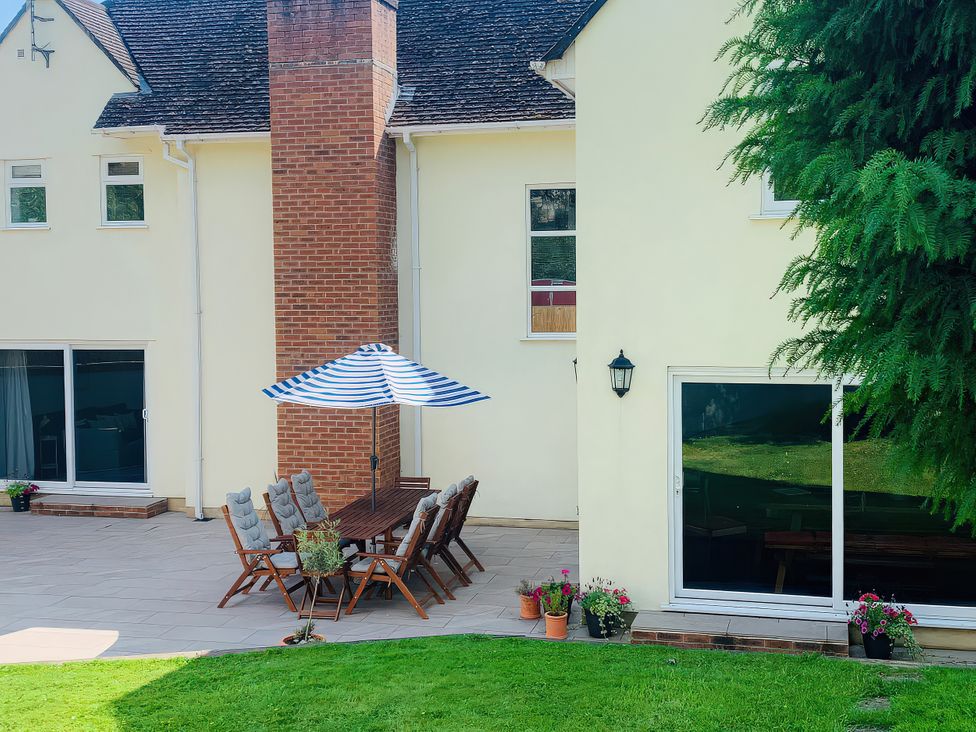 An outdoor patio area with a table and chairs at Brooklands in Uplyme