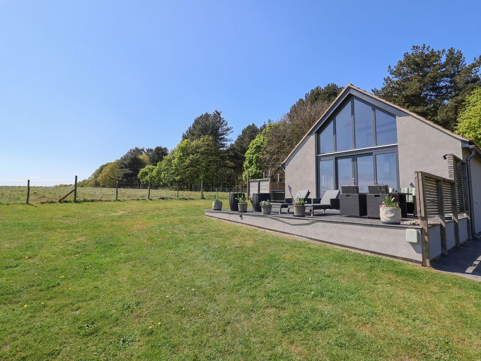 A house with a deck and seating area at Polly's Annexe Levington