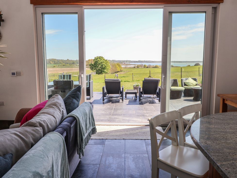 A living room with a view of the patio and landscape at Polly's Annexe Levington