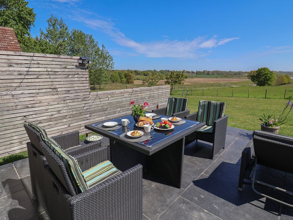 A garden dining setup with a table and chairs at Polly's Annexe Levington