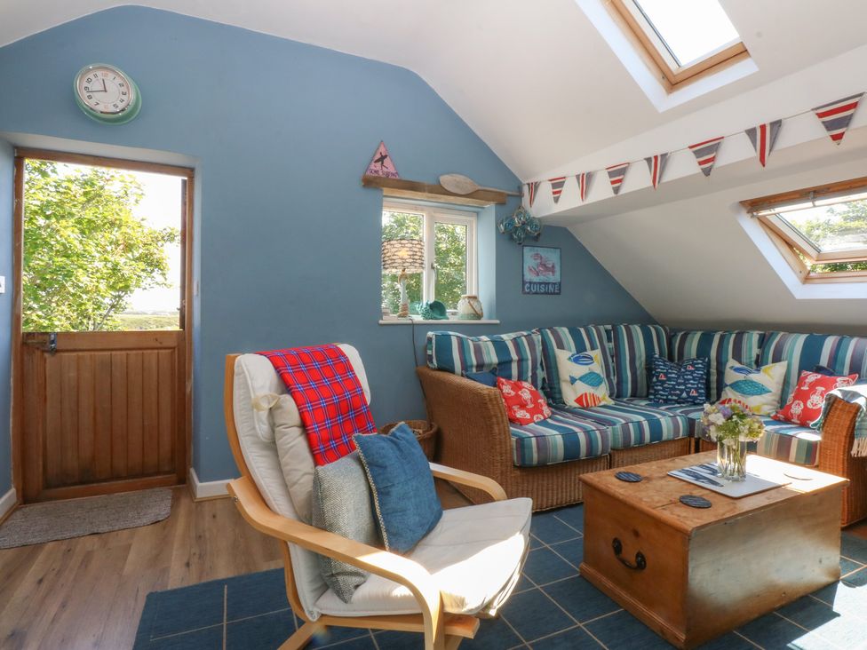 A snug with a couch and table at Borth Arian Boat House in Holyhead