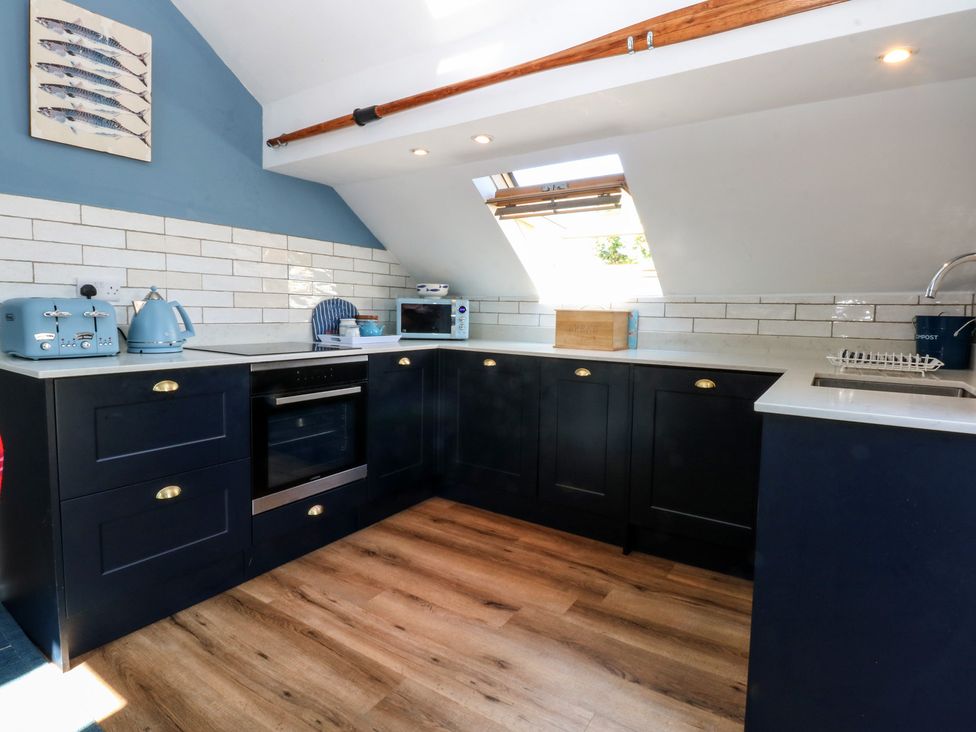 A kitchen with cabinets and appliances at Borth Arian Boat House in Holyhead