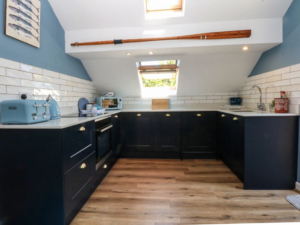 A kitchen with cabinets and appliances at Borth Arian Boat House in Holyhead