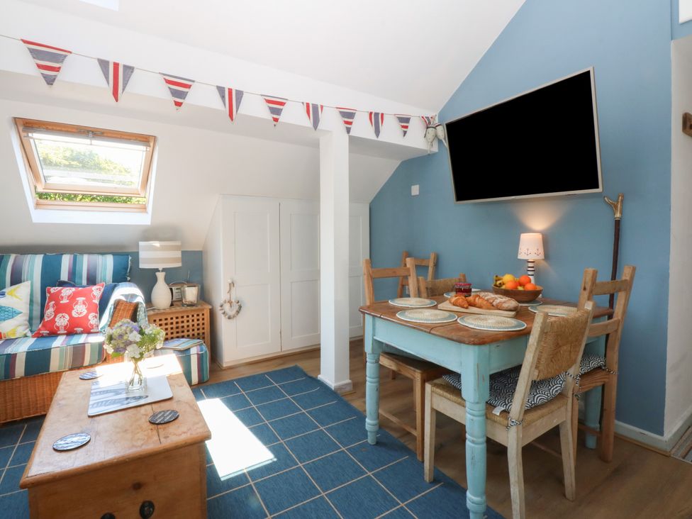 A living room with a sofa and dining table at Borth Arian Boat House in Holyhead