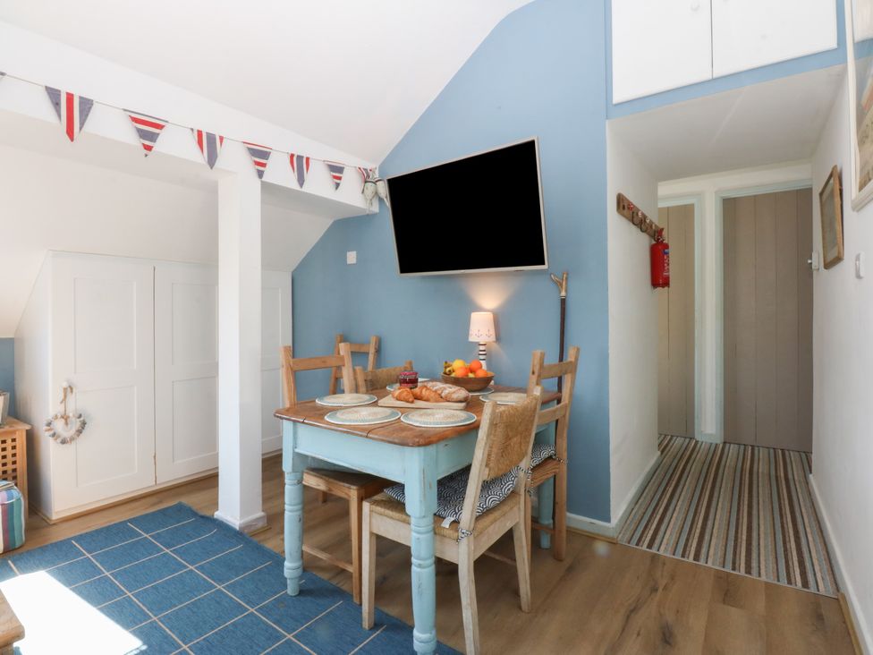 A dining room with a table and chairs at Borth Arian Boat House Holyhead