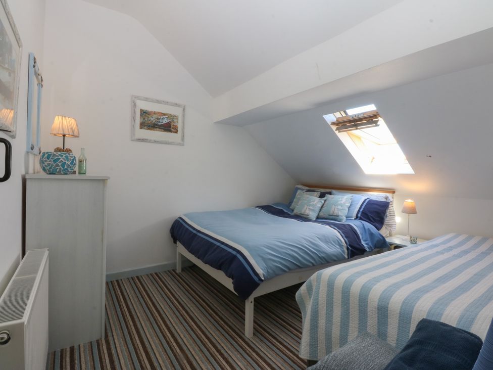 A bedroom with two beds and a window at Borth Arian Boat House in Holyhead