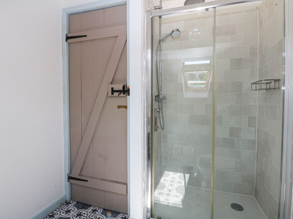 A bathroom with a shower and sliding door at Borth Arian Boat House in Holyhead