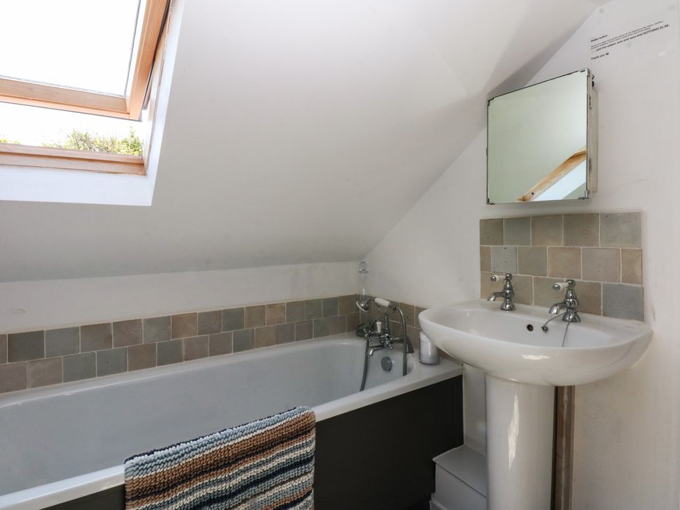 A bathroom with a tub and sink at Borth Arian Boat House in Holyhead