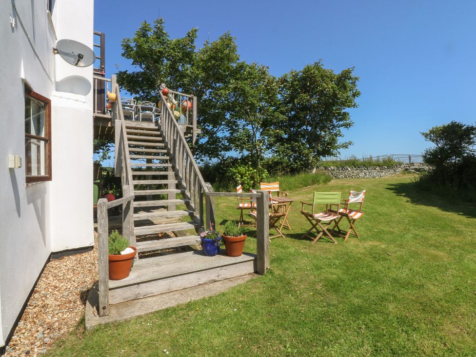 A garden area with stairs leading to a deck at Borth Arian Boat House Holyhead