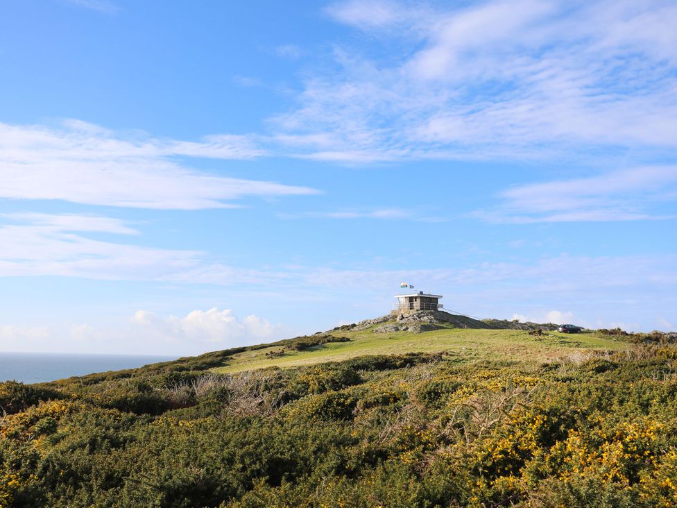 A house on a hill with plants and sky at Borth Arian Boat House in Holyhead