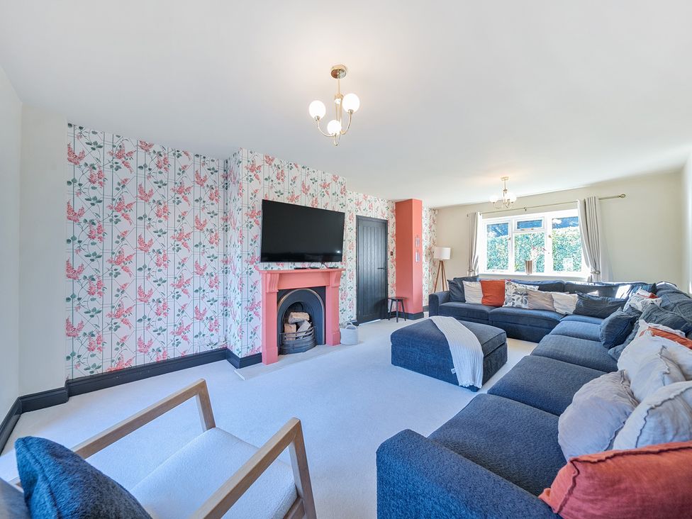 A living room with a television and fireplace at 8 Newmarket Road in Royston