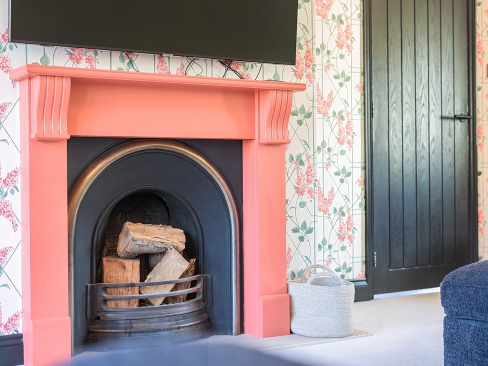 A living room with a fireplace and television at 8 Newmarket Road Royston