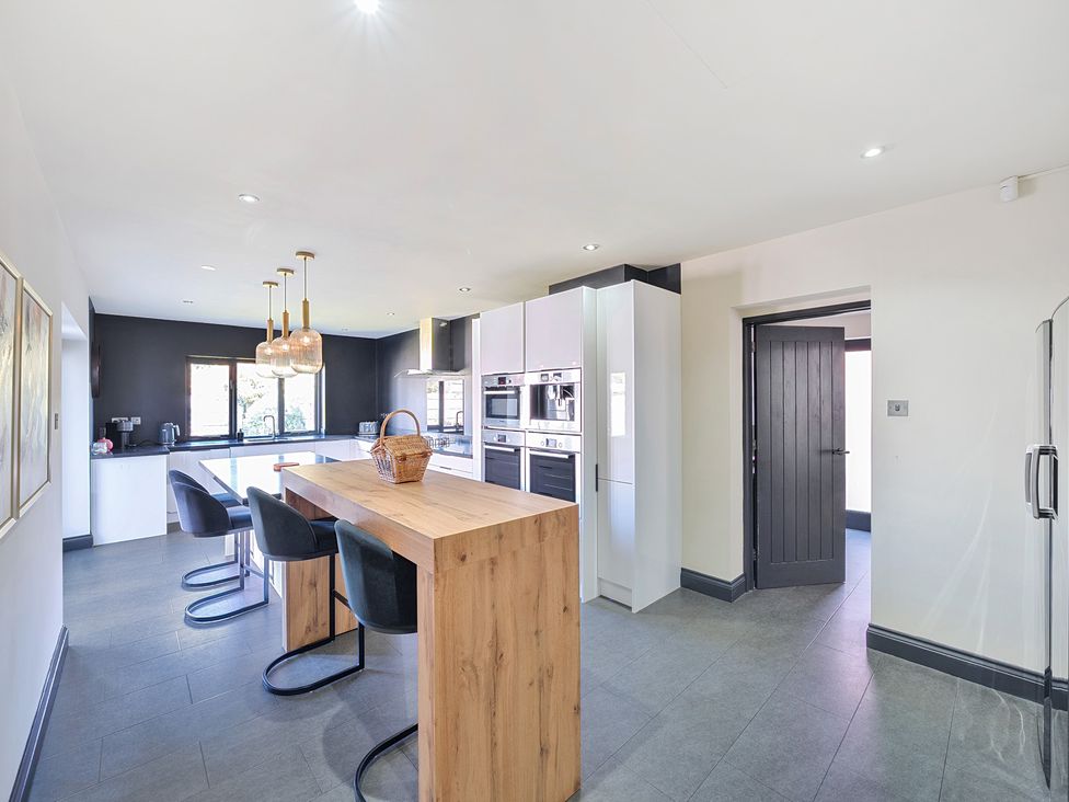 A kitchen with a breakfast bar and appliances at 8 Newmarket Road in Royston