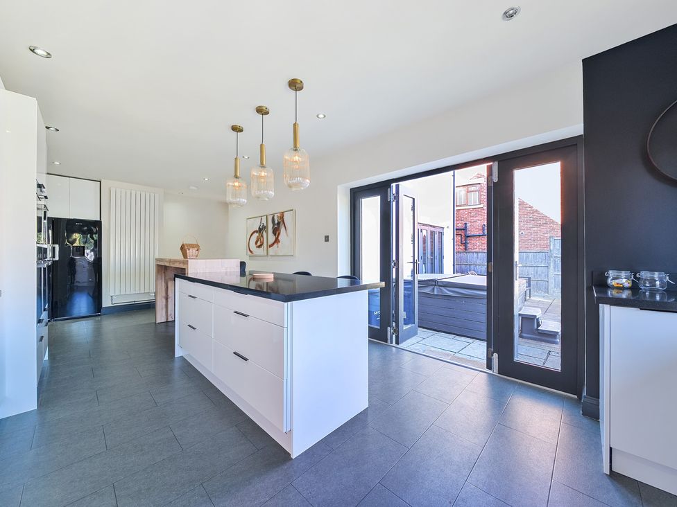 A kitchen with an island and stools at 8 Newmarket Road Royston