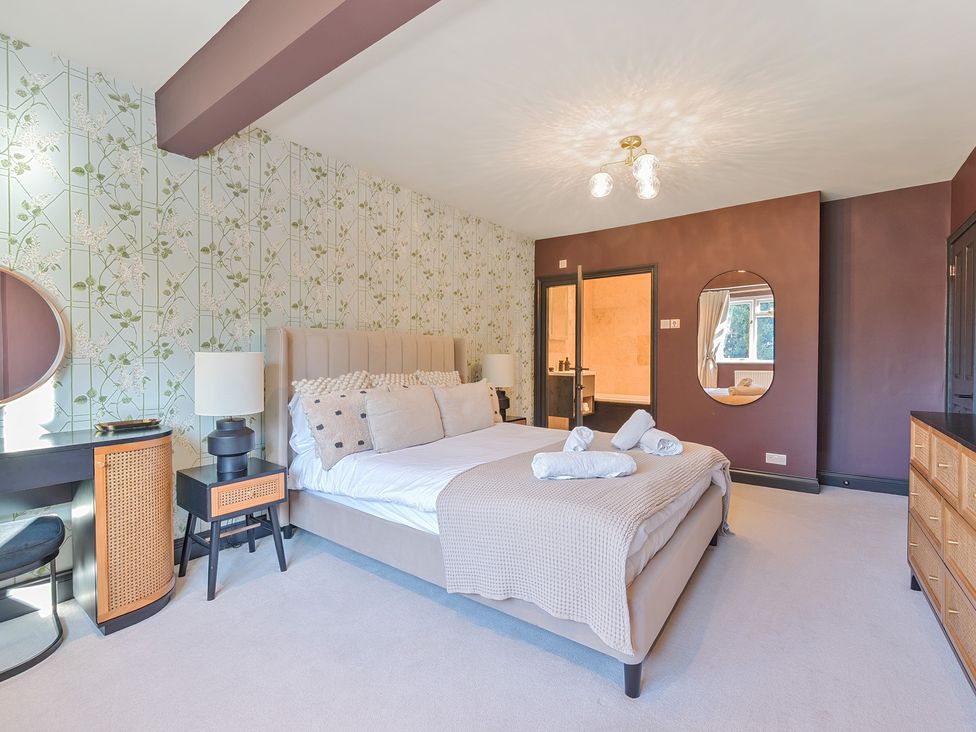 A bedroom with a bed and dresser at 8 Newmarket Road Royston