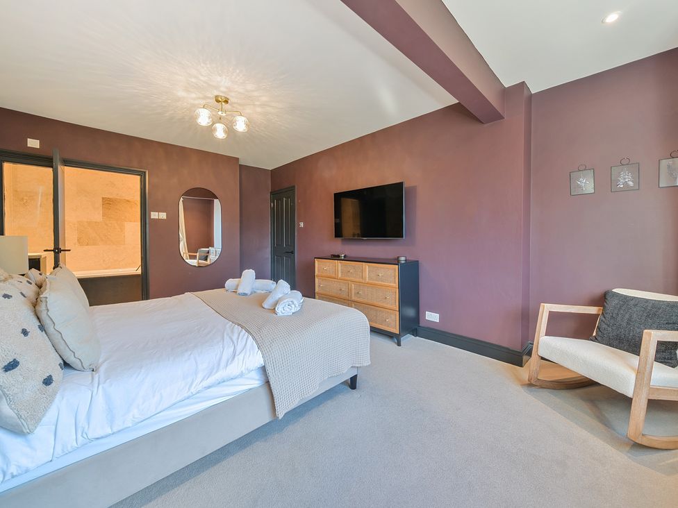 A bedroom with a bed and television at 8 Newmarket Road in Royston