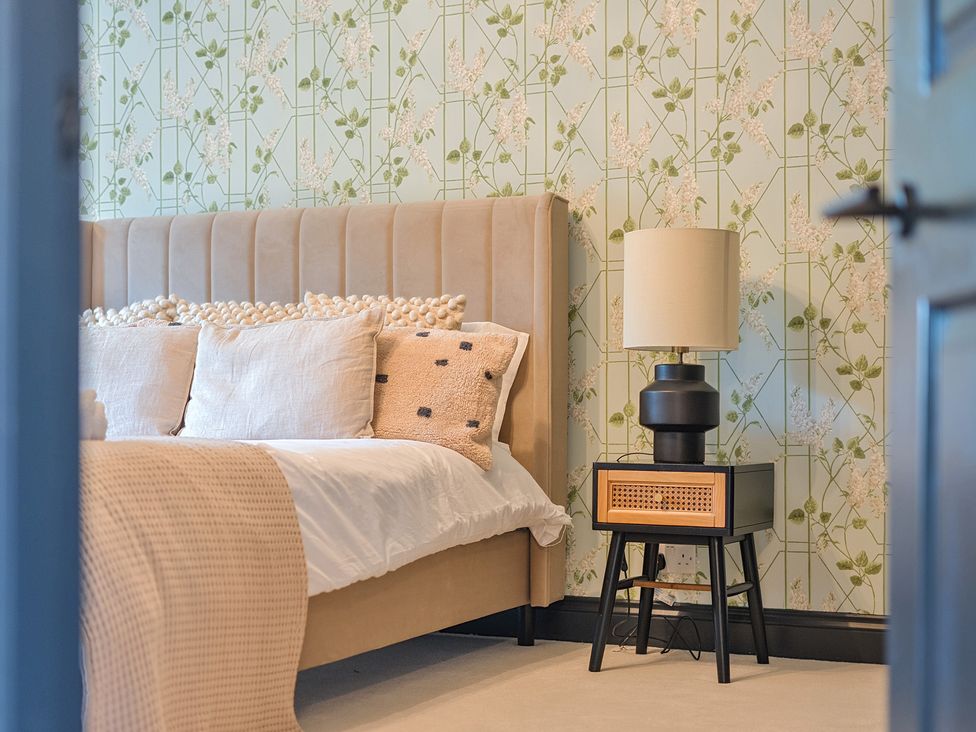 A bedroom with a bed and bedside table at 8 Newmarket Road in Royston