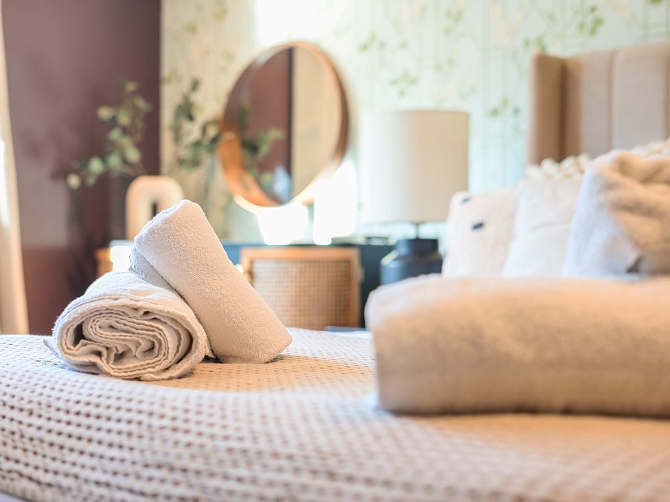 A bedroom with towels on a bed at 8 Newmarket Road Royston