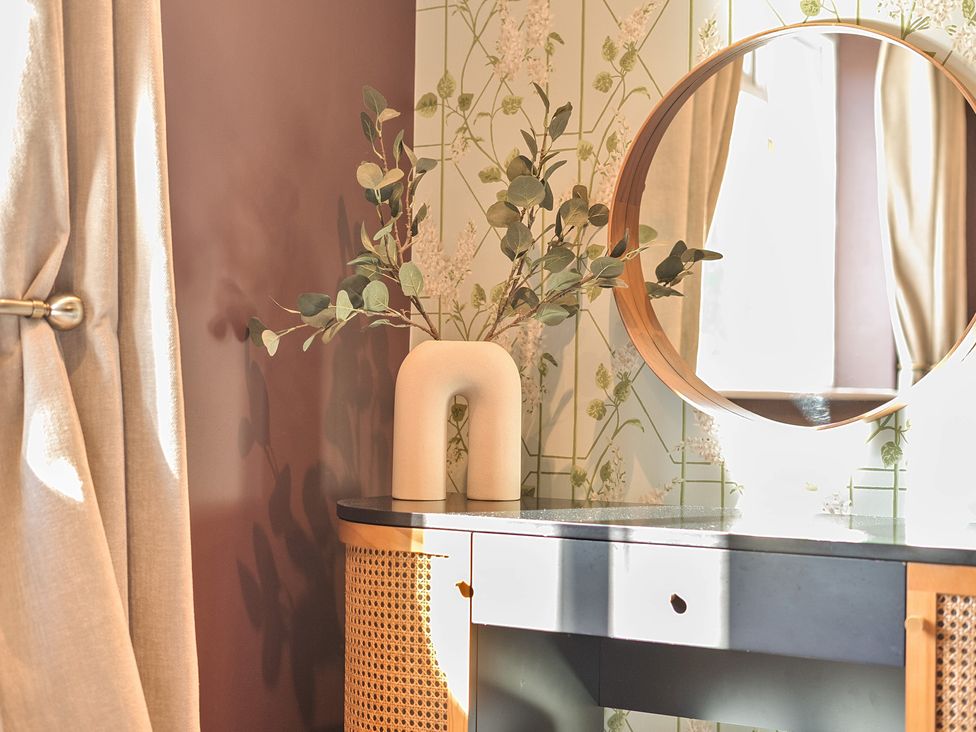 A table with a mirror and plant at 8 Newmarket Road Royston