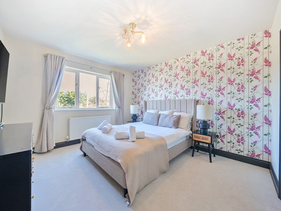 A bedroom with a bed and television at 8 Newmarket Road in Royston