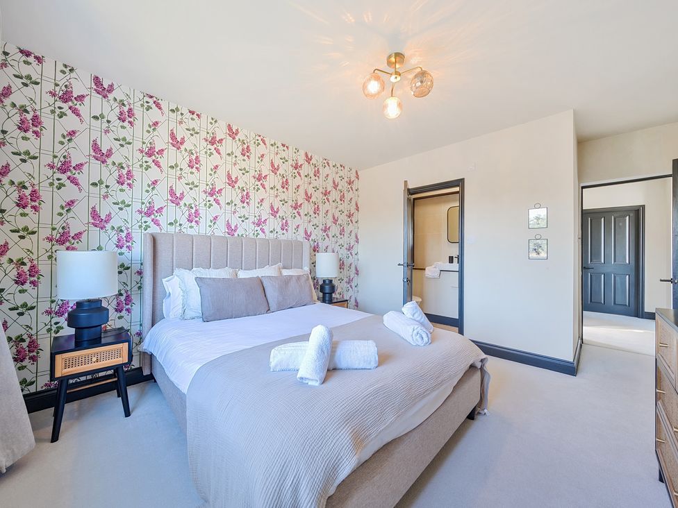 A bedroom with a bed and bedside tables at 8 Newmarket Road in Royston